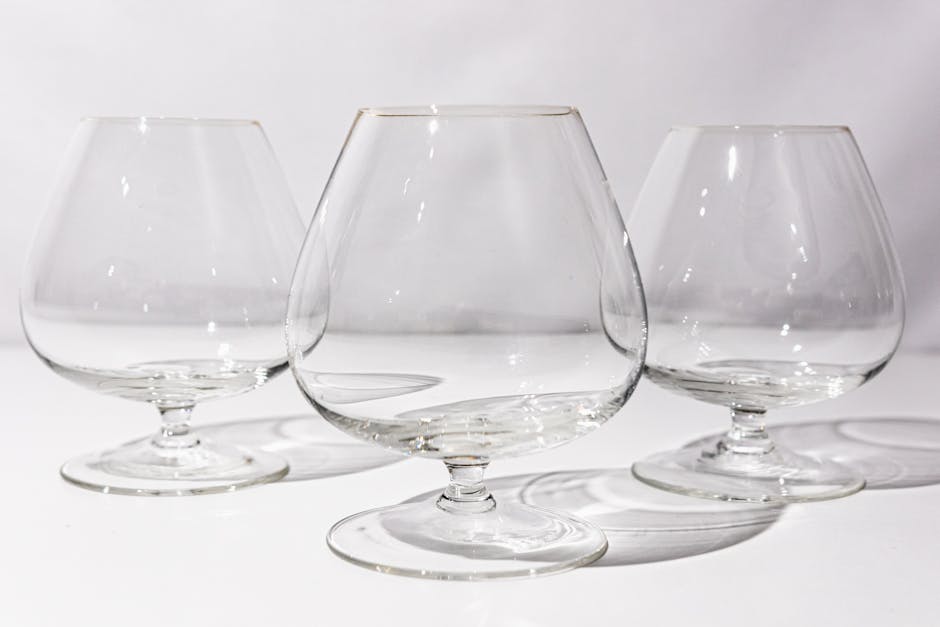 Three empty cognac glasses perfectly lit to highlight their elegant design and reflections.