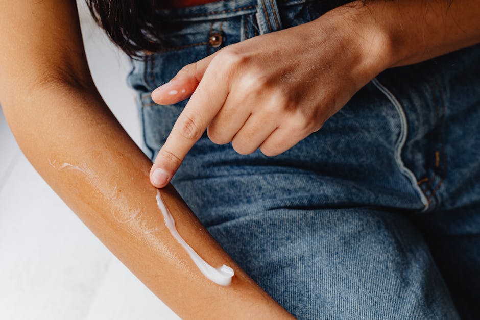 A person applying moisturizing cream to their arm, promoting skincare routine.