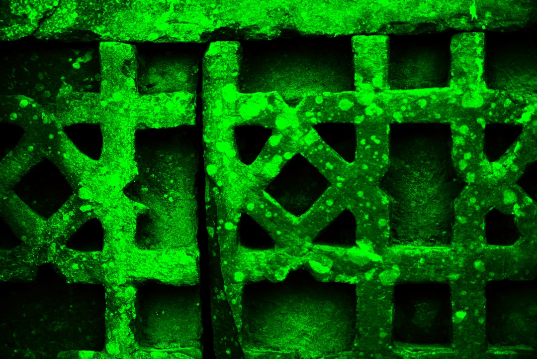 Green textured metal grate with geometric patterns