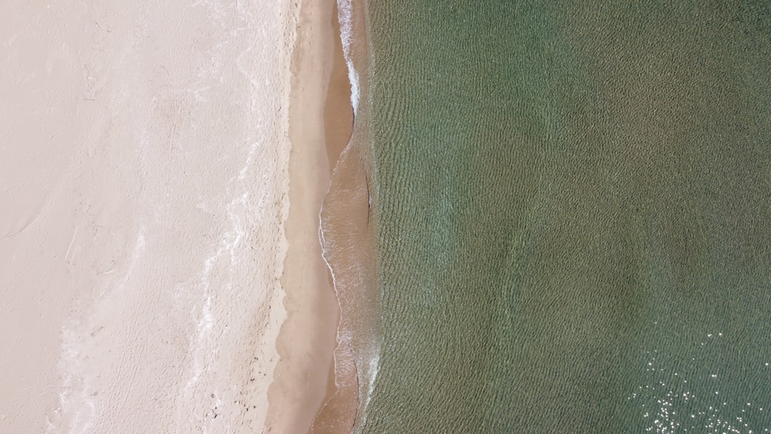 white and green textile beside white sand