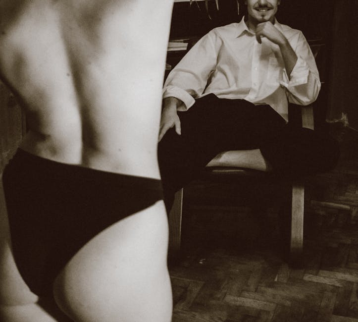 Artistic sepia-toned image capturing intimate moments with playful and erotic elements.